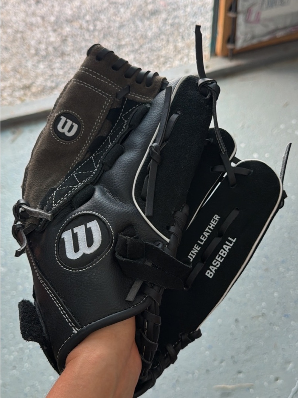 Wilson baseball glove in a classic black and brown leather-style design